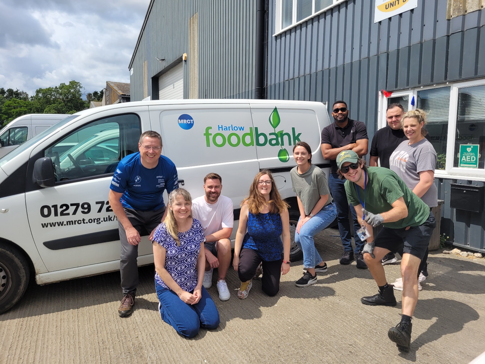 a group of people posing by a food bank van