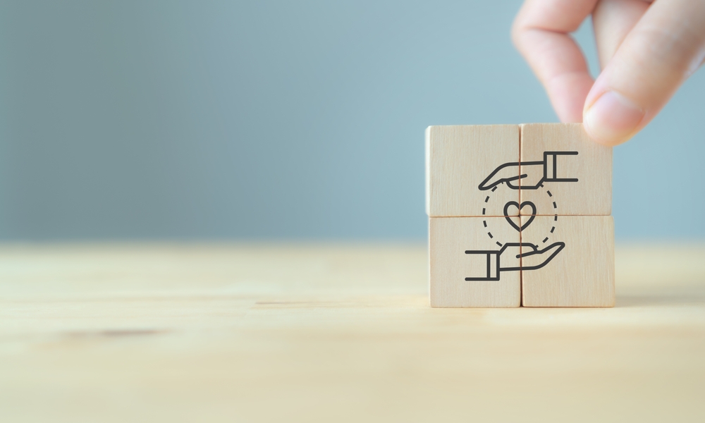 wooden blocks showing a heart surrounded by two palms