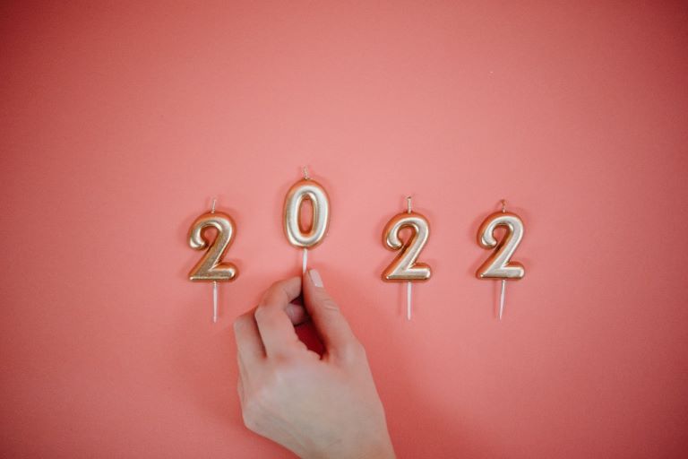 Candles spelling '2022' on a pink background